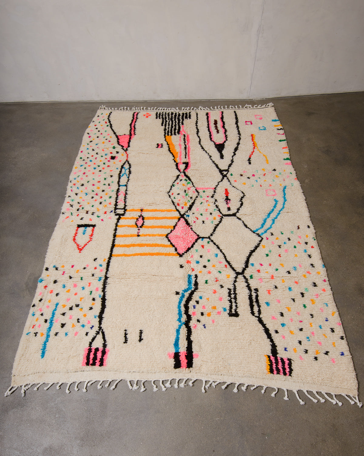 Berberlin Azilal rug made of fluffy wool and cotton, laying flat on a concrete floor.